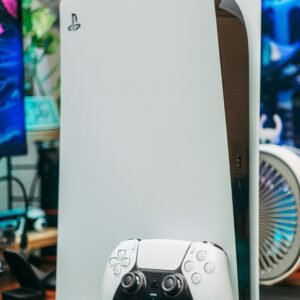 Close-up of PlayStation 5 and controller in an indoor gaming setup.