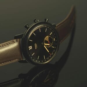 Luxurious black wristwatch with leather strap and analog display in close-up view.